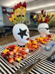 some fruit is on sticks and placed in the shape of people's heads with stars