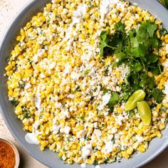 a bowl filled with corn and garnished with cilantro