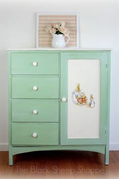 an old dresser painted green and white with pictures on it