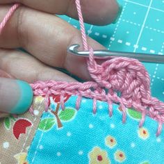 someone is crocheting the stitchs on their fabric to make an ornament