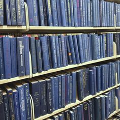 rows of blue books on shelves in a library