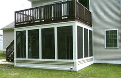 a large screened porch in front of a house with two balconies on the second floor