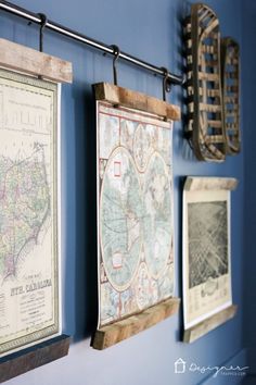 three framed maps hang on the wall next to each other in a room with blue walls