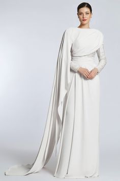 a woman wearing a white gown and cape