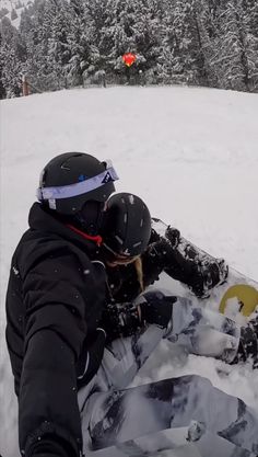 a snowboarder is laying down in the snow