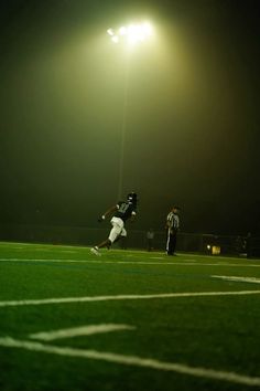 a football player running on the field at night