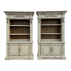 a pair of white painted bookcases with carvings on the top and bottom shelves