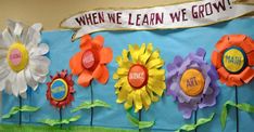 a bulletin board decorated with flowers and the words, when we learn we grow