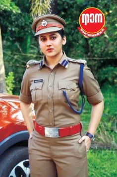 a woman in uniform standing next to a red car with her hands on her hips