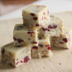 several pieces of white chocolate with cranberry toppings stacked on top of each other