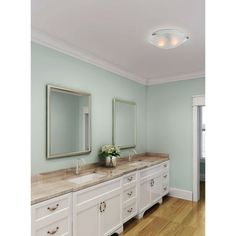 a large bathroom with two sinks and mirrors on the wall, along with hardwood flooring