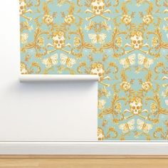 a wallpaper with skulls and bones in gold on a light blue background, next to a white door