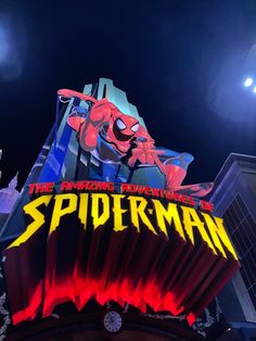 the sign for spiderman is lit up at night