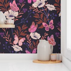 the wall paper has pink and purple flowers on it, along with two white vases