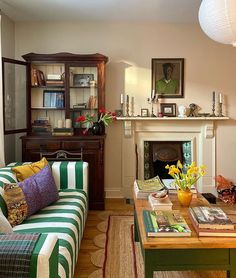 a living room filled with furniture and a fire place under a painting on the wall