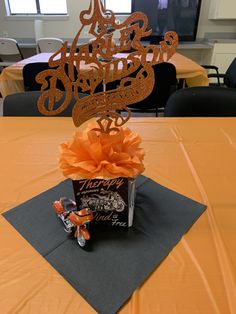 a table topped with a cake and orange ribbon