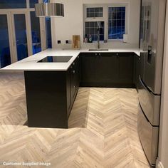 an empty kitchen with wood flooring and stainless steel appliances in the center island area