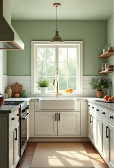 a kitchen with green walls and white cupboards is pictured in this image, the light shines through the window