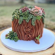 a cake made to look like a tree stump with flowers on top and green leaves