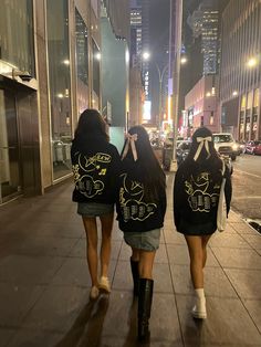 two girls walking down the street wearing matching sweatshirts