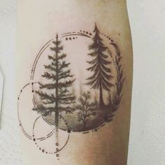 a tattoo on the leg of a person with pine trees and circles around it,