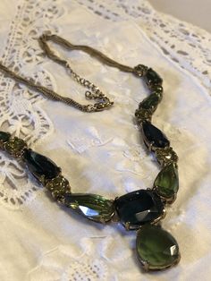 "Vintage Monet green glass stone necklace. Necklace has multiple strands of gold tone chains on each side, and adjustable length. Necklace is stunning, and makes a nice statement piece. Excellent vintage condition. Measures nearly 22\" long total length." Elegant Green Chain Necklace For Formal Occasion, Green Adjustable Chain Necklace For Party, Green Costume Jewelry Necklace, Vintage Green Necklace With Chain, Green Multi-strand Costume Jewelry, Green Metal Costume Jewelry Necklace, Vintage Green Necklace For Evening, Vintage Green Necklaces For Evening, Green Crystal Necklace