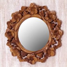 a mirror that is sitting on top of a wooden table next to a white wall