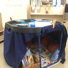 a child's play table in the middle of a room with books and toys