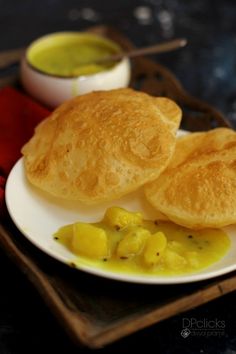 two pieces of bread sitting on top of a white plate next to some dipping sauce