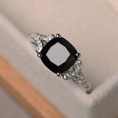 a black and white diamond ring sitting on top of a box