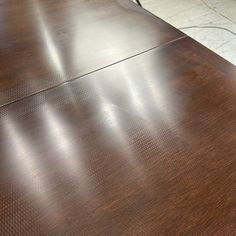 a close up view of a wooden table with metal legs and an oval design on the top