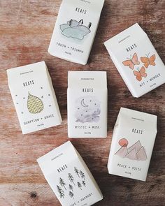 four tea bags sitting on top of a wooden table