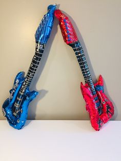 two colorful guitars are hanging on the wall