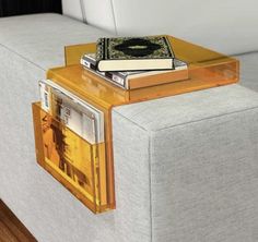 a couch with two books on it and a magazine rack attached to the back end