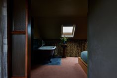 a bathtub and sink in a small room with a skylight above the tub