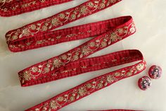 red and gold ribbon with buttons on white surface