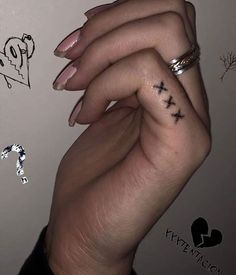 two hands holding each other with tattoos on them