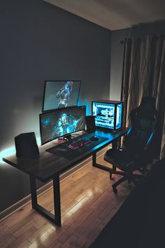 two computer monitors sitting on top of a wooden desk