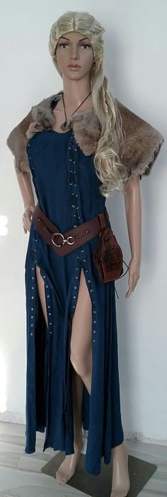 a mannequin dressed in a blue dress and fur stoler is standing next to a white wall