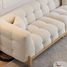 a white couch sitting on top of a rug in a living room