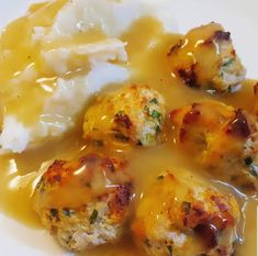 meatballs covered in gravy and potatoes on a plate