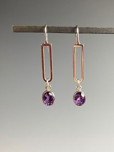 "Sparkly dazzlers of bright purple! These Amethyst earrings are stunning. The open back of their bezel setting allows light to shine through the gemstones and show off their brilliant purple color! All Sterling setting and ear wire. These earrings hang 2 inches and are lightweight and comfortable. These high quality Amethyst gems are faceted and have a lovely color and shine. Mid-century vibe gives all the feels! Comes in a standard gift box and is perfect for a February born gift recipient sinc Modern Purple Dangle Jewelry, Modern Purple Gemstone Earrings, Modern Amethyst Gemstone Earrings, Purple Modern Sterling Silver Earrings, Modern Purple Sterling Silver Earrings, Elegant Purple Earrings For Everyday, Everyday Purple Amethyst Earrings, Purple Gemstone Earrings For Everyday Wear, Everyday Purple Gemstone Earrings