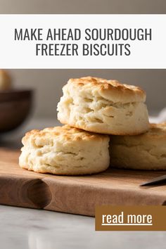 three biscuits sitting on top of a wooden cutting board