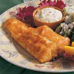 a plate full of food including fish, salad and coleslaw