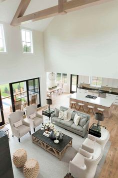 a living room filled with furniture next to a kitchen and an open concept floor plan