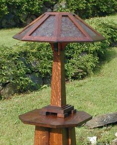 a wooden table lamp sitting on top of a lush green field