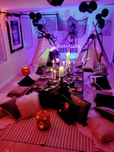 a table with candles and halloween decorations on it in a room decorated for halloween time