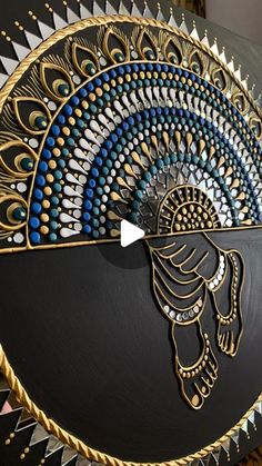 an artisticly designed clock with gold and blue details on it's face, sitting on a table