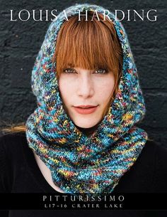 a woman with red hair wearing a multicolored knitted cowl and hood