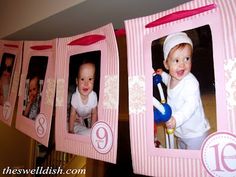 two baby pictures hanging from clothes line with name and number on them in pink frames